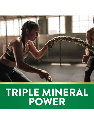 Young woman doing battle rope exercise in a gym with 'TRIPLE MINERAL POWER' text on display.