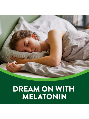 A young woman sleeps peacefully in bed with a bottle of Melatonin on the nightstand.