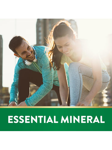 Young man and woman smiling as they tie their shoes under a banner that reads 'ESSENTIAL MINERAL'.