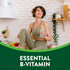 Young adult woman in activewear sits in a kitchen holding a glass of water with 'ESSENTIAL B-VITAMIN' text in view.