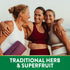 Three middle-aged women smiling and hugging outdoors, with one holding a yoga mat and Tart Cherry product.