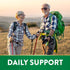 An older man and woman hiking outdoors with walking poles. Text reads 'DAILY SUPPORT'.