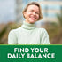 Smiling blonde woman in a light green turtleneck. Below her, a green banner reads 'FIND YOUR DAILY BALANCE'.