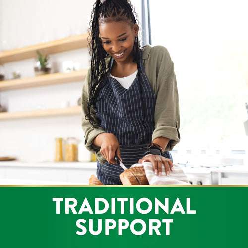 Young Black woman smiling and slicing bread in a kitchen, with a green banner at the bottom stating 'TRADITIONAL SUPPORT'.