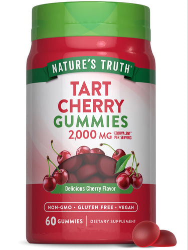 A hand holding a bottle of Tart Cherry 2,000 MG equivalent gummies, with a notable balance of supplements seen in the scale.