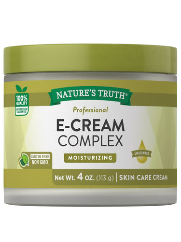 Hand holding E-Cream Complex skin care cream, 4 oz (113 g), showcasing the product's size and design.