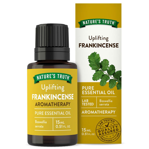 Bottle of Uplifting Frankincense Pure Essential Oil 15 mL with accompanying product box shown in someone's hand for scale.