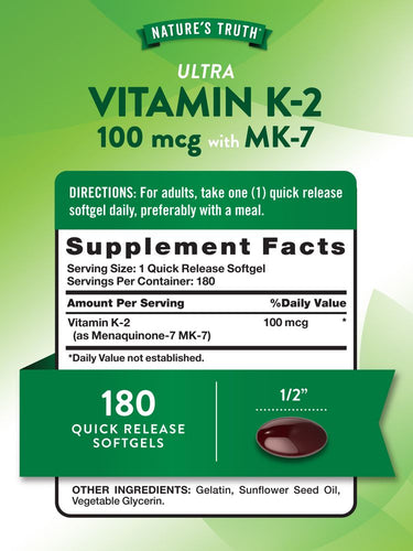 A dark red oval softgel capsule on a hand, measuring approximately 1/2 inch in length.