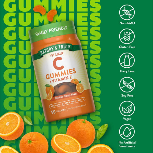 A hand holds two orange, slice-shaped Vitamin C gummies on a scale, showcasing their size and shape for easy comparison.