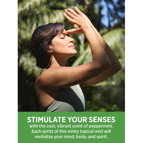 Adult woman, eyes closed, hands near face, enjoys scent of Peppermint Spray in a natural outdoor setting.