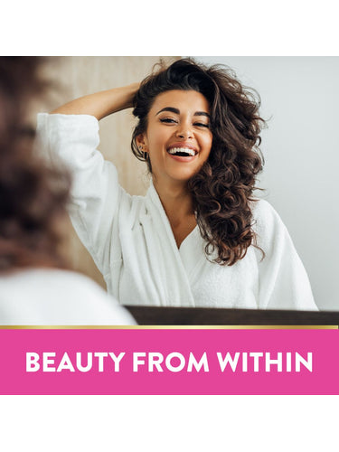 Young woman in white bathrobe smiling while touching her curly hair. Text: BEAUTY FROM WITHIN.