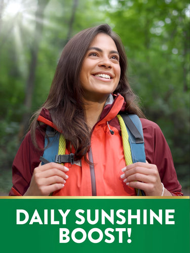 Young woman hiking in a forest, smiling towards the sun with a green graphic stating 'DAILY SUNSHINE BOOST!'
