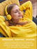 Young woman relaxing with eyes closed, wearing yellow headphones, enjoying refreshing, purifying, uplifting Lemon oil.