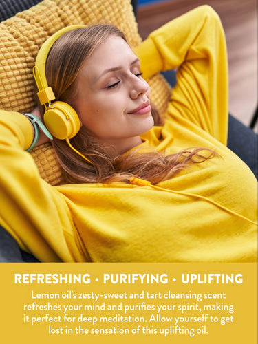 Young woman relaxing with eyes closed, wearing yellow headphones, enjoying refreshing, purifying, uplifting Lemon oil.