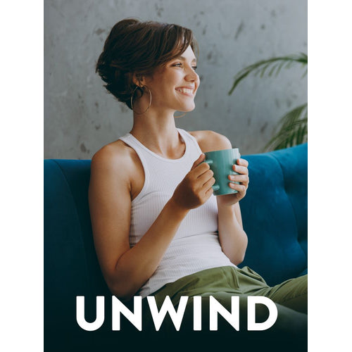 Young woman sits on a blue sofa, holding a teal mug and smiling. The word 'UNWIND' is displayed at the bottom.