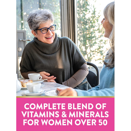 Two women over 50 talking and laughing at a cafe table with coffee and cake. Text: COMPLETE BLEND OF VITAMINS & MINERALS FOR WOMEN OVER 50.
