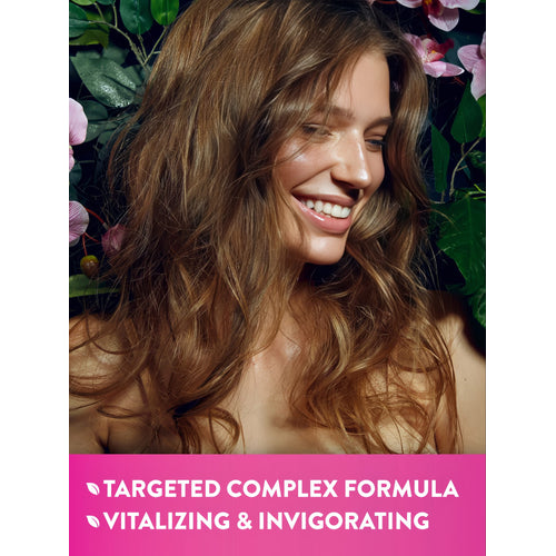 Young woman with wavy brown hair smiles among plants. Banner reads: 'TARGETED COMPLEX FORMULA', 'VITALIZING & INVIGORATING'.