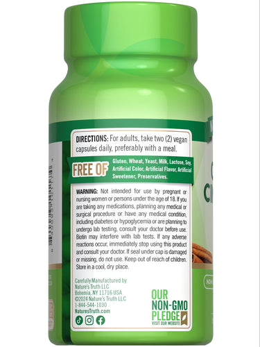 A hand holds a bulk scale displaying two vegan capsules.