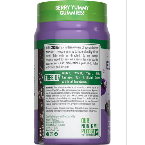A handful of dark purple, berry-shaped NT Kids Elderberry Complex gummies are shown.