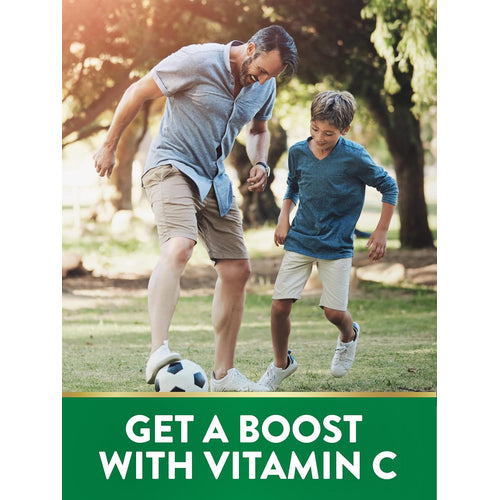 Father and son playing soccer in a park. Text on image reads: 'GET A BOOST WITH VITAMIN C.'