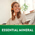 Young woman smiling, wearing headphones, holding a ukulele, with 'ESSENTIAL MINERAL' text on a green banner.