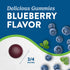 A 3/4-inch blueberry flavor gummy next to fresh blueberries.