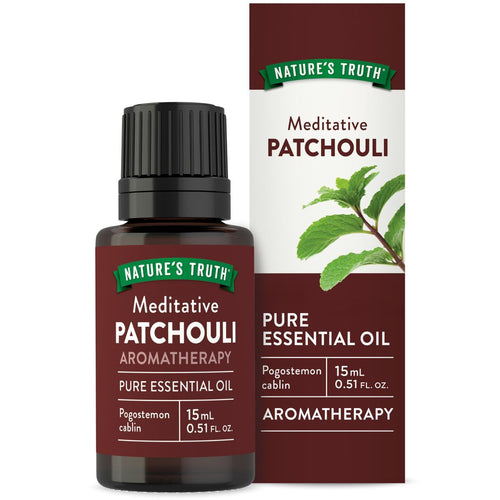 Hand holding Nature's Truth Meditative Patchouli Pure Essential Oil, 15 mL bottle in front of box.