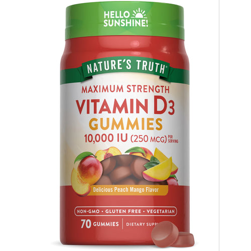 Hand holding two Vitamin D3 10,000 IU (250 MCG) gummies on a bulk scale.