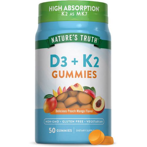 A close-up of a hand holding orange, circular D3 + K2 Gummies, showcasing their size and texture on a bulk scale.