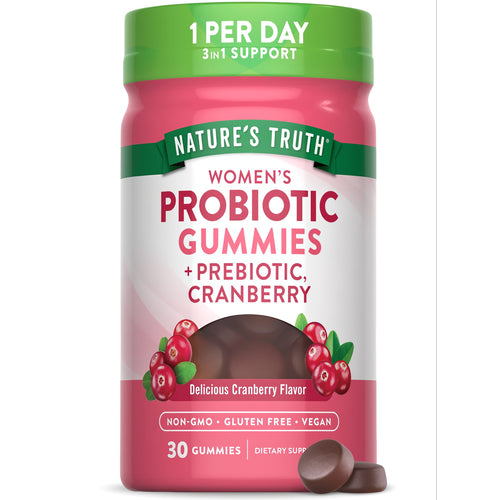 A hand holding two dark brown, round gummies, highlighting their texture and shape on a transparent scale background.