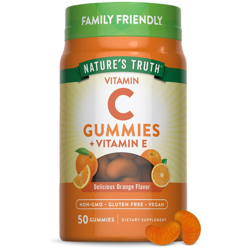 Gummies shaped like orange slices, containing Vitamin C and Vitamin E, are placed on a hand scale for measurement.