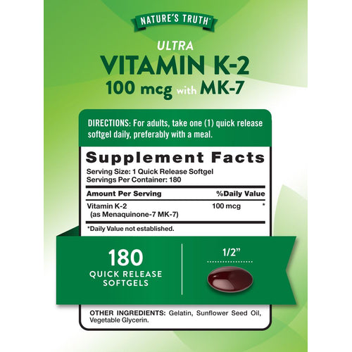 View 2 A dark red oval softgel capsule on a hand, measuring approximately 1/2 inch in length.