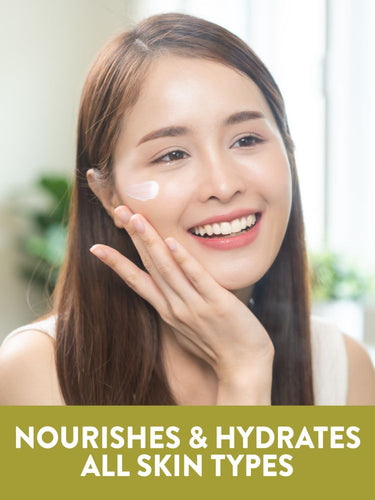 Young woman applying NT JW Vitamin E-Cream to cheek. Graphic text reads: Nourishes and hydrates all skin types.