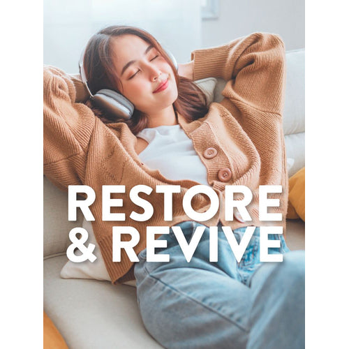 View 4 A young woman relaxes on a couch with headphones, eyes closed. White text reads 'RESTORE & REVIVE'.