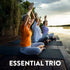 Three senior women practicing yoga with raised arms on mats by a lake at sunset. Text: ESSENTIAL TRIO.