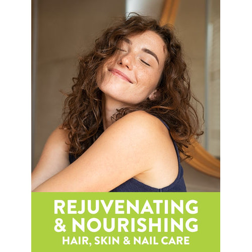 Smiling young woman with curly hair and freckles, eyes closed. Green banner: REJUVENATING & NOURISHING HAIR, SKIN & NAIL CARE.