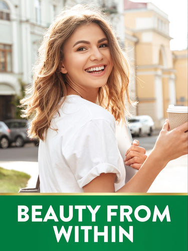 Smiling woman outdoors with laptop and coffee. Green banner with gold trim shows 'BEAUTY FROM WITHIN'.
