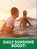 Young man and woman surfing in the ocean at sunset with graphic text 'DAILY SUNSHINE BOOST!', NT D3.
