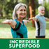 Senior woman and man doing yoga outdoors, with a green banner at the bottom stating 'INCREDIBLE SUPERFOOD'.