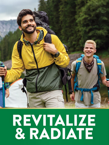 Two men hiking in a forest; one older man in a yellow jacket, one younger man smiling, both with backpacks and trekking poles, for D3.