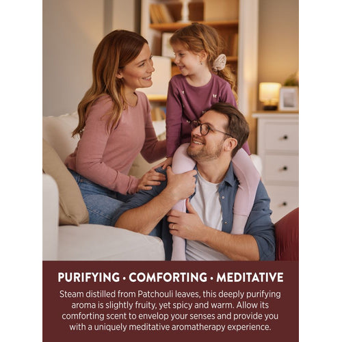 A family (mother, father, young daughter) smiling and interacting on a couch, daughter on father's shoulders, with Patchouli Oil.