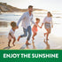 Family of four, a man, woman, and two girls, run on a beach. Green banner reads: ENJOY THE SUNSHINE.