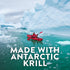 A person in a red kayak paddles in turquoise water with ice floes and large icebergs. Text: 'MADE WITH ANTARCTIC KRILL'.