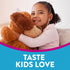 Young girl smiling, hugging a brown stuffed dog while listening with earphones. Graphic text reads 'TASTE KIDS LOVE'.