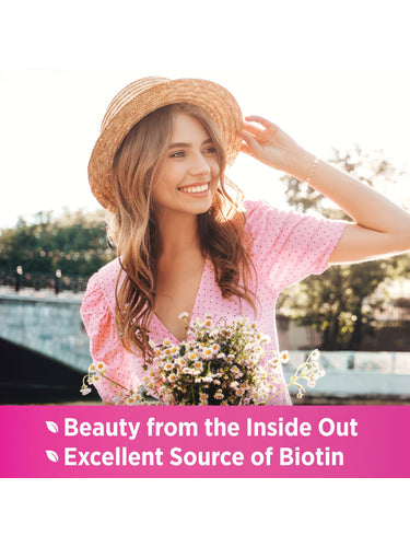 Young woman in hat holds flowers and smiles outdoors. Text: 'Beauty from the Inside Out,' 'Excellent Source of Biotin'.
