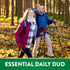 Middle-aged couple hiking in fall forest with trekking poles. Graphic text: ESSENTIAL DAILY DUO.