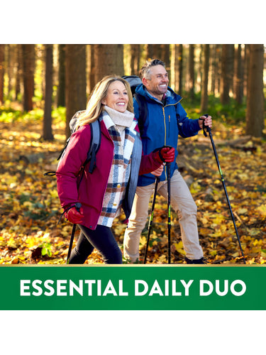 Middle-aged couple hiking in fall forest with trekking poles. Graphic text: ESSENTIAL DAILY DUO.