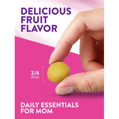 A hand holds a delicious fruit-flavored gummy, measuring three-quarters of an inch, against a bulk scale backdrop.