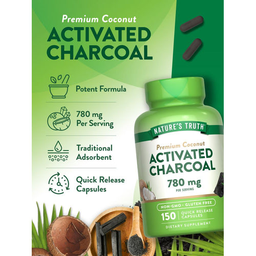 A hand holds two dark gray activated charcoal capsules.