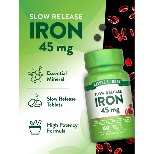 Dark grey, slow-release Iron 45 mg coated tablets on a hand-held scale for precise weight measurement.